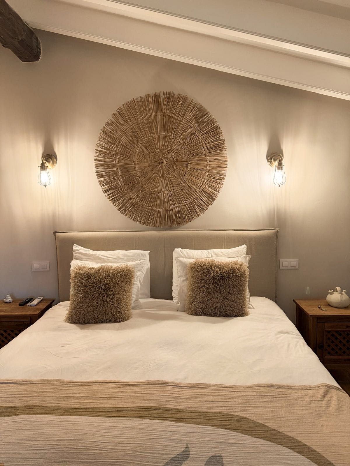 Slaapkamer met kingsize bed en rieten wandobject