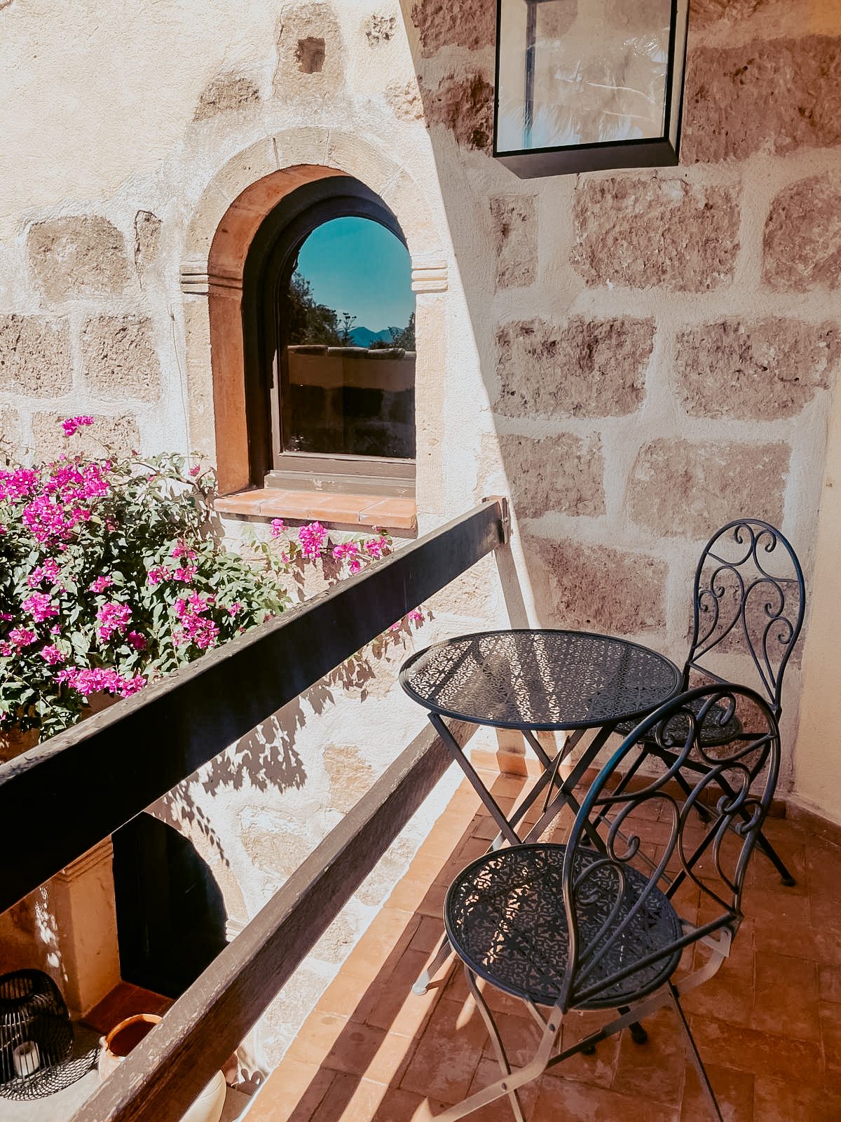 Balkon met smeedijzeren tafeltje en bougainville