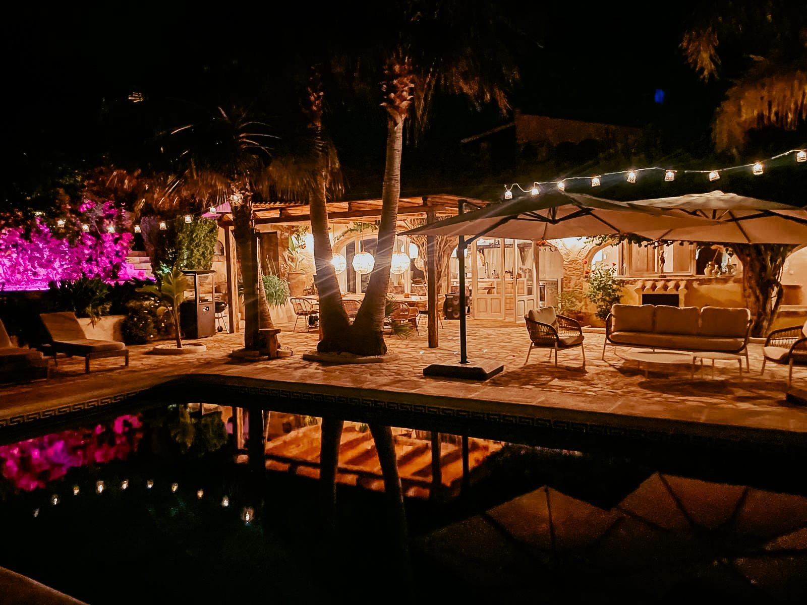 Het verlichte terras en zwembad in de avond