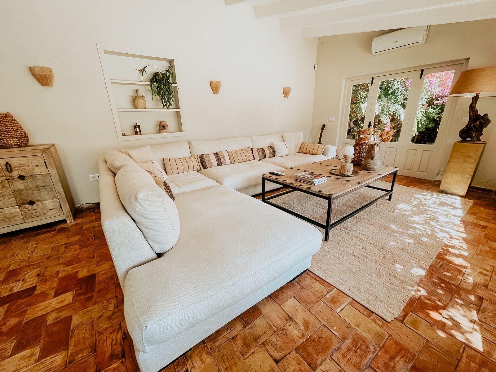 Woonkamer met terracotta vloer en openslaande deuren